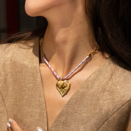 Collier pendentif en acier inoxydable doré, orné d'un trèfle et d'un soleil en forme de cœur.