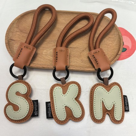 1 breloque de sac en cuir de couleurs mélangées avec lettres