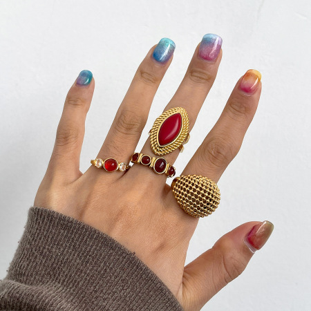 Bague tendance en acier inoxydable doré, ornée d'une pierre naturelle rouge de forme irrégulière.