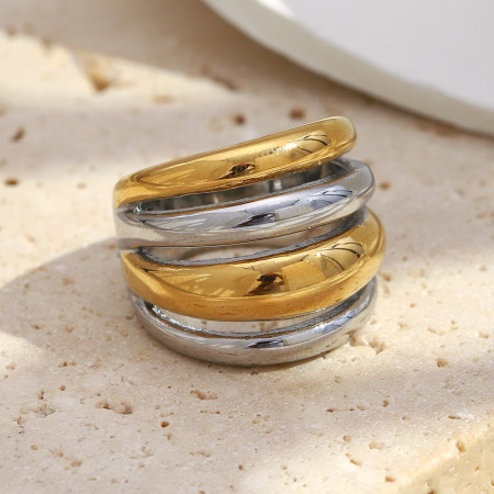 Bague imposante en acier inoxydable doré et argenté, ornée de plusieurs cercles et étanche.