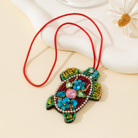 Collection luxueuse de perles de style océanique représentant une petite tortue naturelle, en corde tressée et pierres précieuses artificielles.