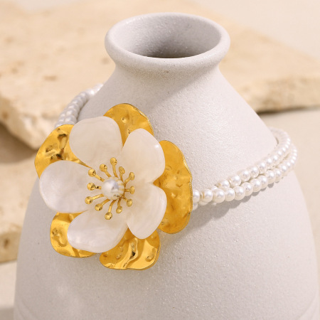 Bracelet pour femme en acier inoxydable doré, imperméable, orné de perles artificielles et d'un motif floral romantique.