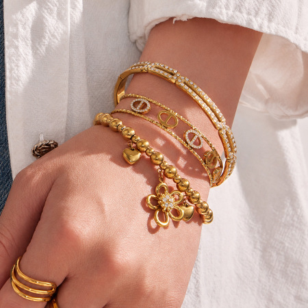 Bracelet manchette pour femme en acier inoxydable doré, étanche, avec zircon et motif floral géométrique.