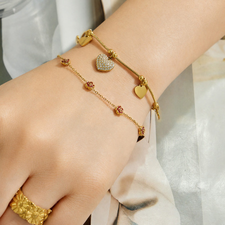 Bracelet à breloques pour femme, élégant, en acier inoxydable, couleur or, orné d'une fleur et d'un cœur. Collection luxueuse.