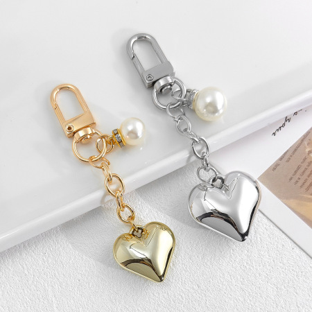 Porte-clés romantique en alliage, orné d'un nœud papillon et d'une perle artificielle, en forme de cœur simple et uni. Collection Romantique.