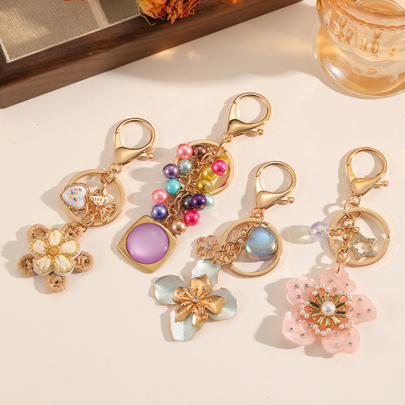 Porte-clés en cuivre de la série Luxueuse, orné de perles en forme de cœur, d'étoile tissée, de papillon et de formes géométriques multicolores, avec fleurs et cœurs. Motifs géométriques.