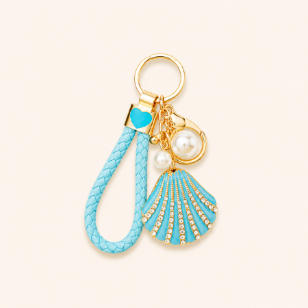 Porte-clés luxueux et décontracté de style océanique, en métal tressé et strass, orné de coquillages. Collection Luxueuse.